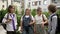 Teenage classmates happily chat in the schoolyard after class. School friendship.