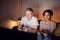 Teenage Couple Sitting On Sofa At Home Computer Gaming Together