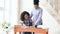 Teenage curly haired mixed race young girl sitting at the table concentrating focused learning lessons and her elder