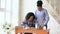 Teenage curly haired mixed race young girl sitting at the table concentrating focused learning lessons and her elder