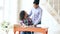 Teenage curly haired mixed race young girl sitting at the table concentrating focused learning lessons and her elder