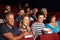 Teenage Family Watching Film In Cinema