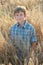 Teenage farmer standing among barley field