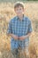 Teenage farmer standing among field of barley