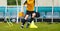 Teenage football player running on the training pitch. Young boy practicing soccer using sports equipment