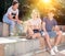 Teenage friends discussing and browsing on phones on summer streets