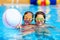 Teenage friends playing with ball in the pool