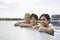 Teenage Friends Resting At The Edge Of Swimming Pool