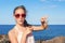 Teenage funny wondering girl holding an atlantic crab on ocean c