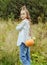 Teenage girl 11 with a bag of vegetables, pumpkin on the background of greenery in nature