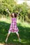 Teenage Girl With Arms Raised Jumping In Nature