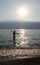 Teenage girl, bathing in a lake, morning sun.