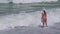 Teenage girl in a bathing suit happily jumps in the waves of Persian Gulf on beach of Dubai stock footage video
