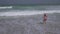 Teenage girl in a bathing suit happily jumps in the waves of Persian Gulf on beach of Dubai stock footage video