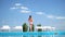 Teenage girl in bathing suit stands between sun loungers by pool