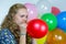 Teenage girl blowing inflating colored balloons