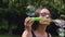 Teenage girl blowing soap bubbles in summer