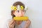 A teenage girl with a bouquet on her head eats corn