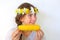 A teenage girl with a bouquet on her head eats corn