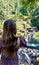 Teenage girl in brown trendy dress Standing over a cliff above a waterfall In British Columbia Englishman river falls