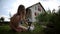 Teenage girl caressing rabbit in front of the house