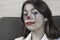 a teenage girl with clown makeup talks about something emotionally