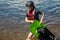 A teenage girl comes out of the water and carries Wake Board. Sports for children and teenagers. Summer pastime. Children`s sport