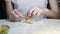 A teenage girl cooks dumplings with potatoes for dinner at the table.