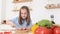 A teenage girl cooks in the kitchen, she cuts red pepper. Happy teenage girl helps mom