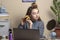 A teenage girl with curlers looks at the mirror. beautiful teenage girl doing her hair in front of the laptop