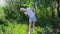 A teenage girl does gymnastics in the garden in the summer. Exercise bends to the side.