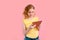 A teenage girl does her homework on a tablet. The student works and communicates with friends. Pink background with free space