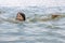 A teenage girl enjoys swimming in the calm warm sea water in beautiful summer weather