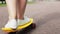 Teenage girl feet riding short modern skateboard