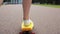 Teenage girl feet riding short modern skateboard
