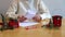 A teenage girl folds a letter to Santa Claus at the table.