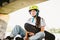 Teenage girl in helmet and stylish clothes posing on half pipe ramp an outdoor skate park. Beautiful kid female model skateboarder