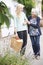 Teenage Girl Helping Senior Woman To Carry Shopping