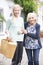 Teenage Girl Helping Senior Woman To Carry Shopping