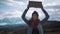 Teenage Girl Holding An Adventure Sign On A Mountain Road, Smiles And Laughs