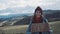 Teenage Girl Holding An Adventure Sign On A Mountain Road, Smiles And Laughs