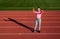 teenage girl holding barbells and water bottle. fitness coach prepare for workout. warming up on stadium gym. power and