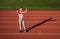 teenage girl holding barbells and water bottle. fitness coach prepare for workout. warming up on stadium gym. power and