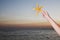 Teenage girl holding starfish, close up on human arm