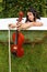 Teenage girl holding violin and fiddlestick outdoor in bathtub