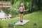 A teenage girl holds an apple and a banana in her hand after undergoing an online outdoor training near her home. Sports. Healthy