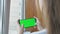 A teenage girl holds a phone with a green screen in her hands while standing on the balcony. Caucasian girl plays on the