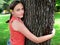 Teenage girl hugging tree