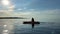 Teenage girl is kayaking at sunset in Pacific Ocean, only the silhouette of Kayak Paddles is visible she swims along