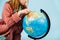 Teenage girl looking for her home on a globe.